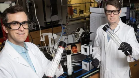 Scientists in a labratory holding equipment