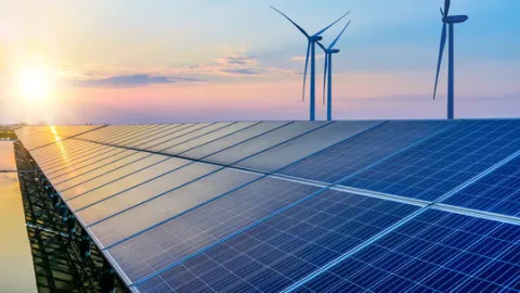 Soler panels and wind turbines in front of a sunset