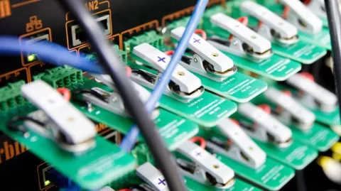 Clips holding button cells connected to a networked device.