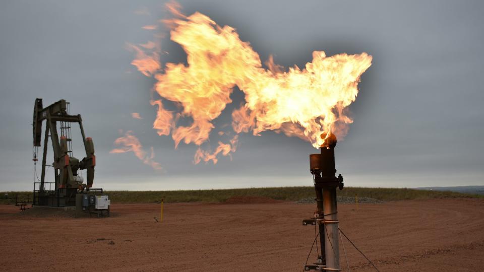 A flare burns natural gas at an oil well on Aug. 26, 2021, in Watford City, N.D. 